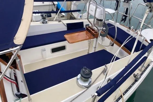 Slide: The Image of 1985 Catalina 36 sailboat cockpit with blue cushions and wooden table. - 17