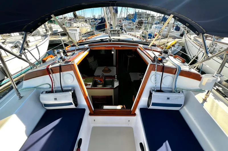 Slide: The Image of Cockpit view of a 1985 Catalina 36 sailboat, showcasing interior and marina surroundings. - 27