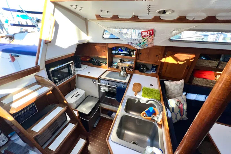 Slide: The Image of Interior of 1985 Catalina 36 sailboat with kitchen, sink, and wooden cabinetry. - 31