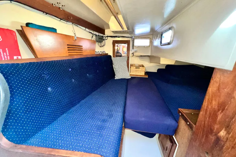 Slide: The Image of Interior of 1985 Catalina 36 sailboat with blue upholstered seating and wooden accents. - 34