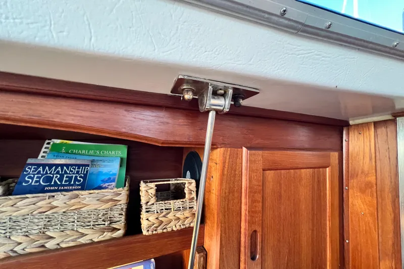 Slide: The Image of Interior of 1985 Catalina 36 sailboat with books and wooden cabinetry. - 52