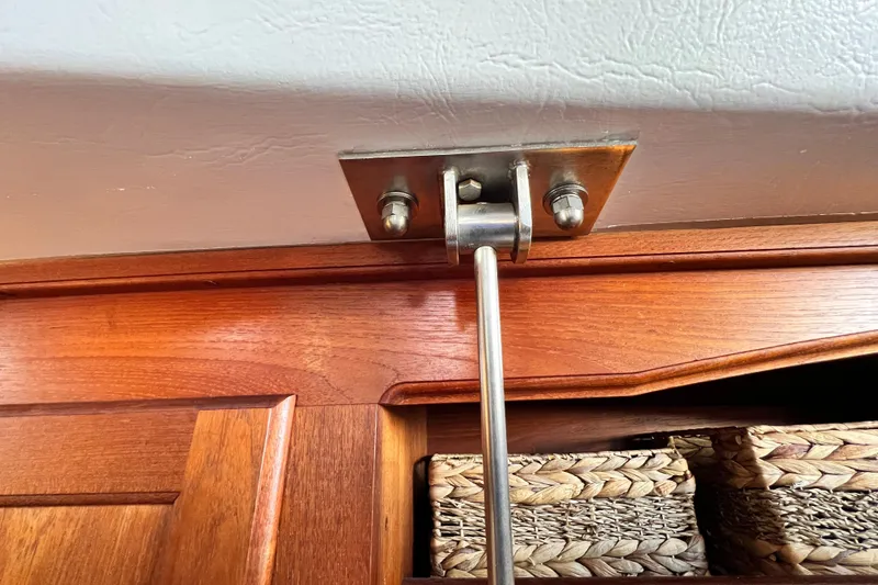 Slide: The Image of Interior detail of a 1985 Catalina 36 sailboat showing a metal support rod and wooden cabinetry. - 53