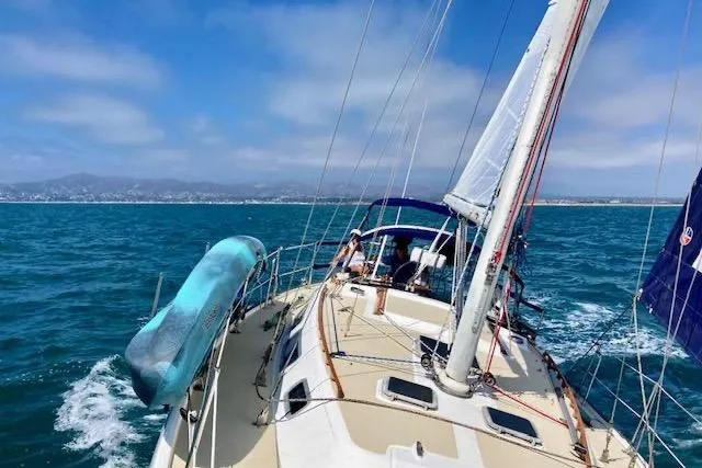 Slide: The Image of 1985 Catalina 36 sailboat navigating blue ocean under clear skies. - 6