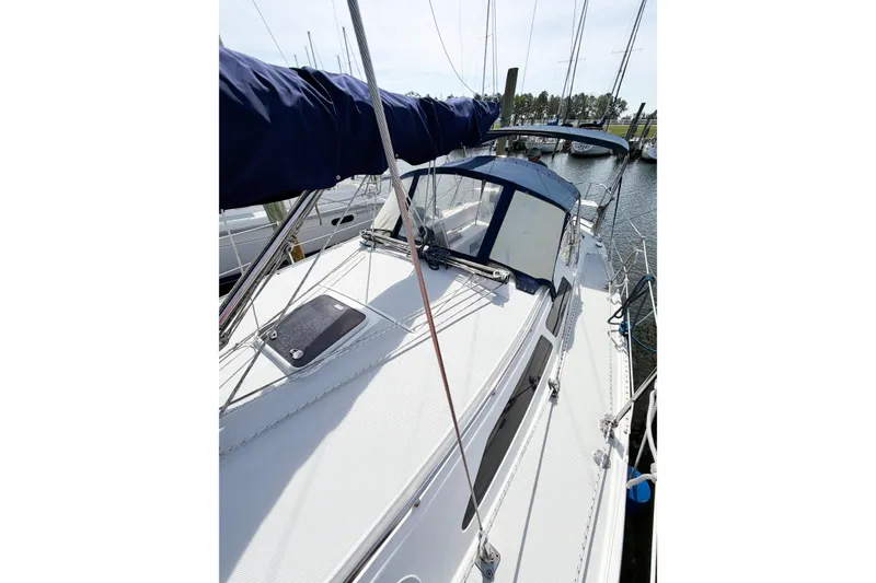 Slide: The Image of 2003 Catalina 34 MkII sailboat docked, featuring a sleek deck and blue canopy. - 14
