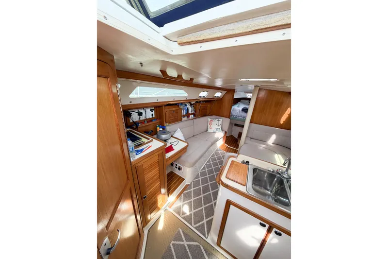Slide: The Image of Interior of a 2003 Catalina 34 MkII sailboat, featuring a cozy cabin with wood finishes. - 32
