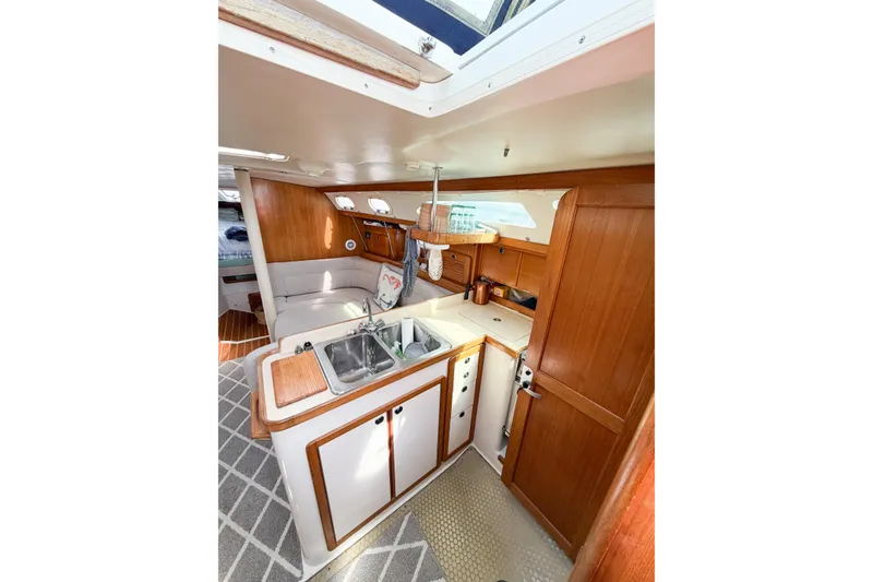 Slide: The Image of Interior of 2003 Catalina 34 MkII sailboat featuring a cozy kitchen and seating area. - 33