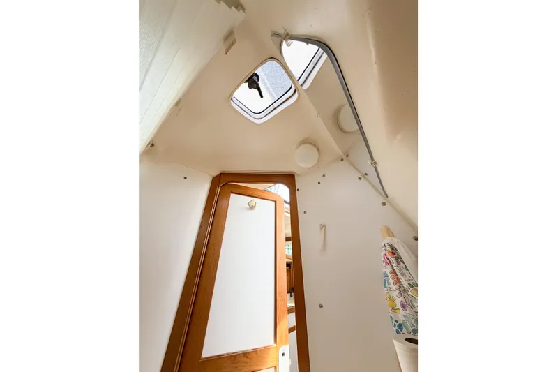 Slide: The Image of Interior view of a 2003 Catalina 34 MkII sailboat cabin with wooden door and hatch. - 59