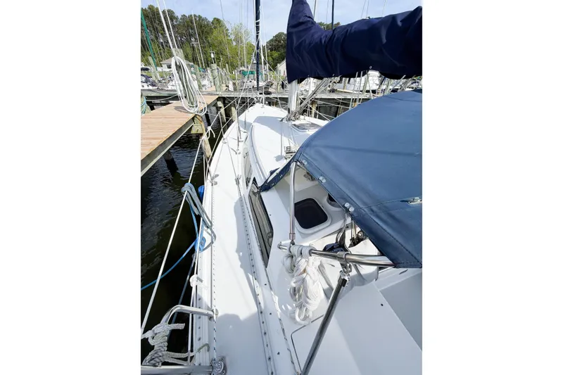 Slide: The Image of 2003 Catalina 34 MkII sailboat docked, featuring blue canopy and deck details. - 6