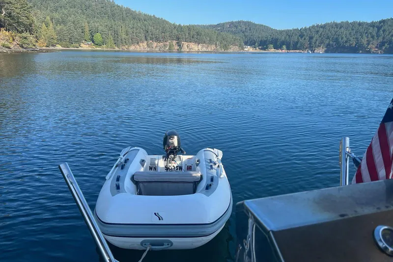 Slide: The Image of Bayliner 2859 Ciera Classic 2002 with inflatable boat on serene lake. - 26