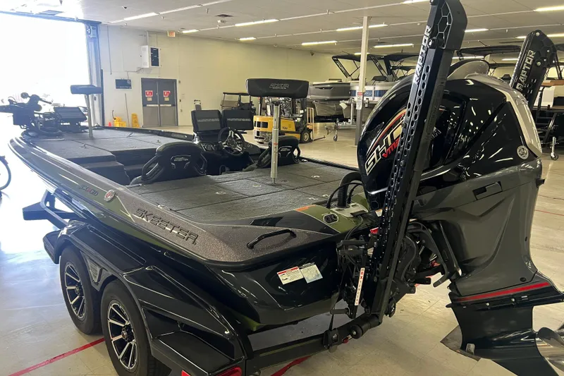 Slide: The Image of 2024 Skeeter FXR21 Apex boat with Minn Kota trolling motor, parked outdoors. - 2