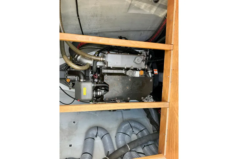Slide: The Image of Engine compartment of a 2016 Lagoon 450 S catamaran, showcasing mechanical components and hoses. - 103