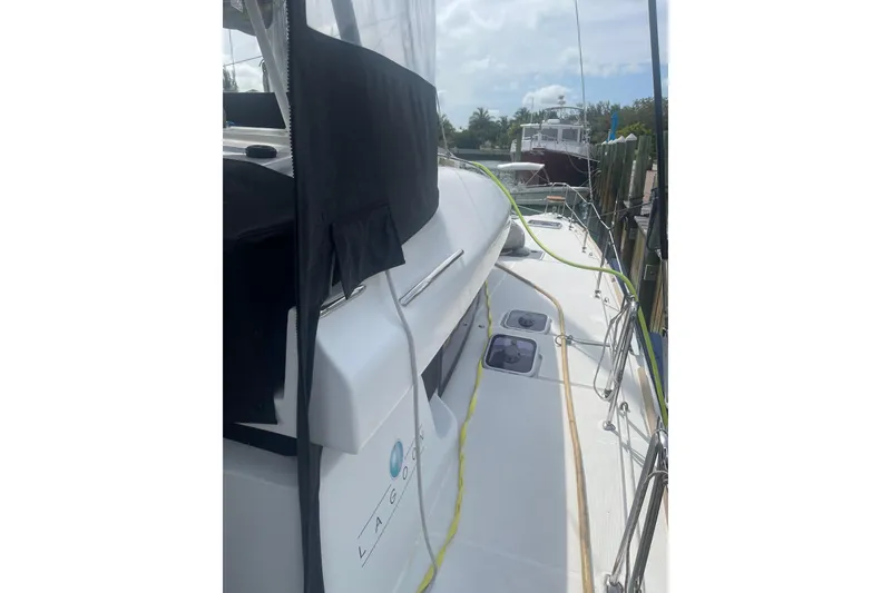 Slide: The Image of 2016 Lagoon 450 S catamaran docked, showcasing deck and side view. - 13