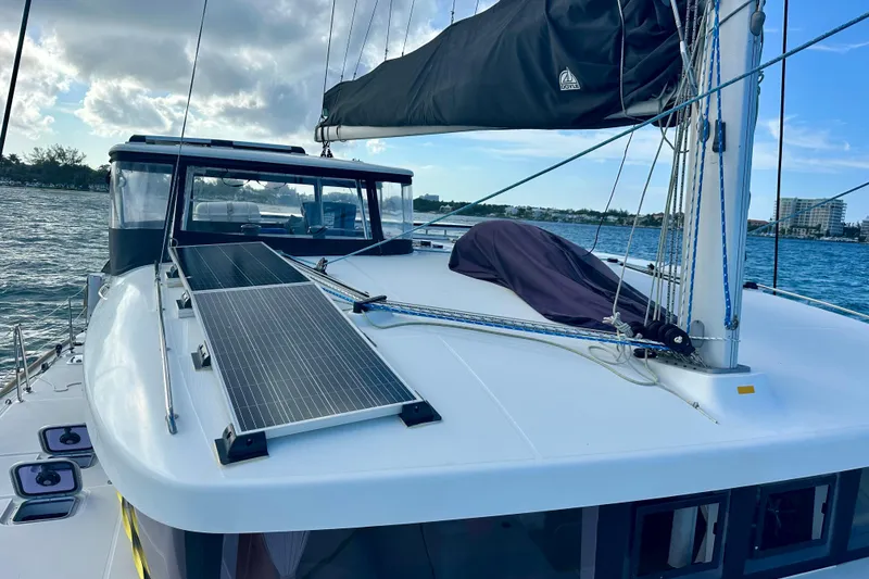 Slide: The Image of 2016 Lagoon 450 S catamaran with solar panels on deck, sailing in calm waters. - 16