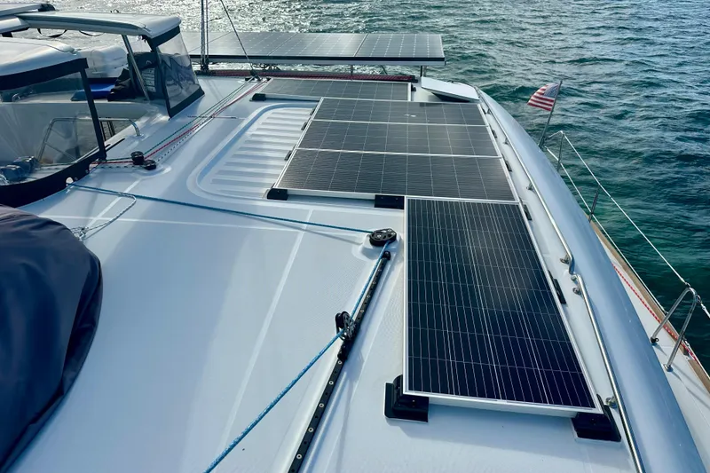 Slide: The Image of 2016 Lagoon 450 S catamaran with solar panels on deck, sailing on open water. - 24
