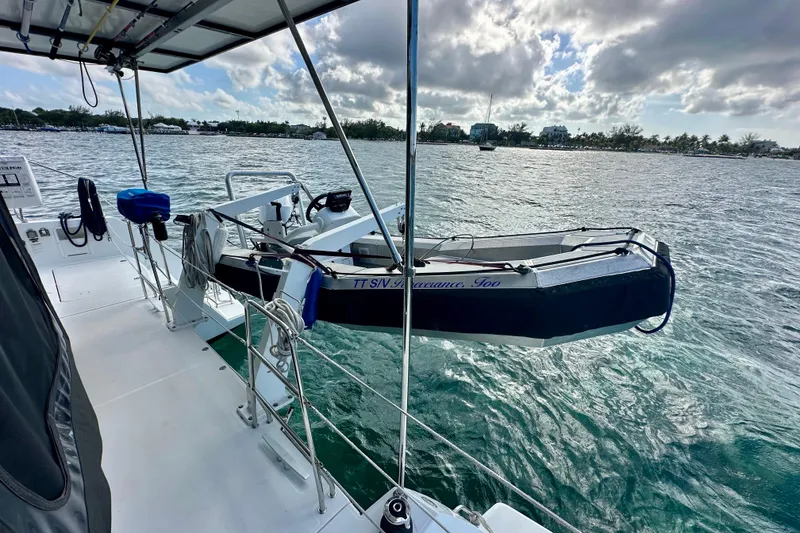 Slide: The Image of 2016 Lagoon 450 S catamaran with dinghy on calm waters under cloudy sky. - 29
