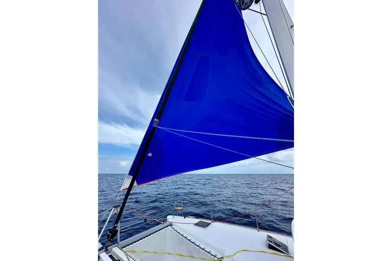 Slide: The Image of Sailing on a 2016 Lagoon 450 S catamaran with a vibrant blue sail against the ocean backdrop. - 41
