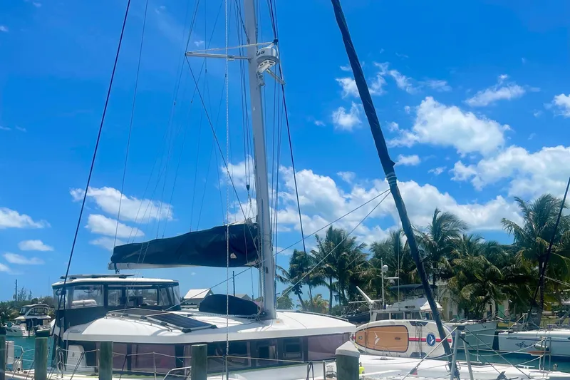 Slide: The Image of 2016 Lagoon 450 S catamaran docked under a clear blue sky with palm trees. - 5