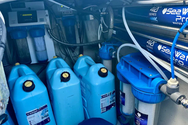 Slide: The Image of Water filtration system in a 2016 Lagoon 450 S yacht, featuring blue containers and filters. - 57