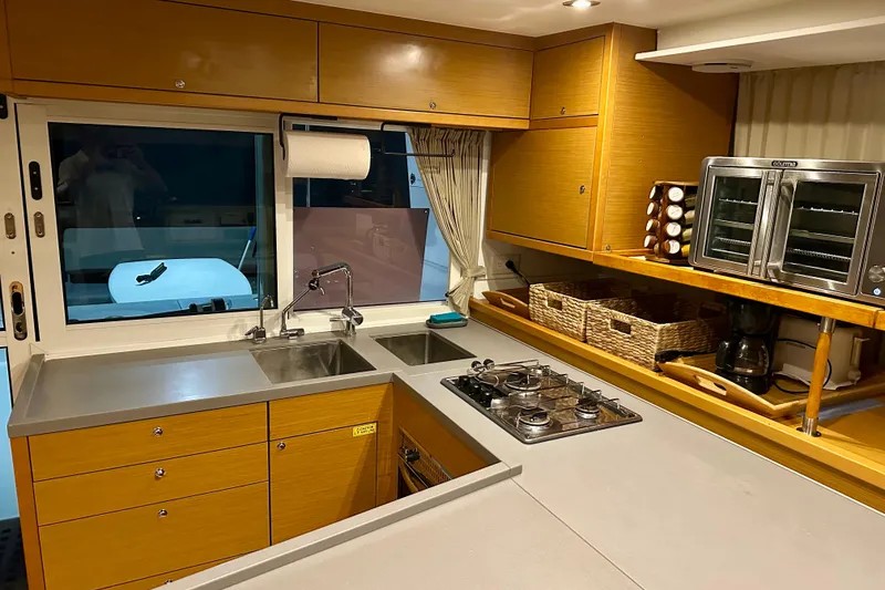 Slide: The Image of Modern kitchen interior of 2016 Lagoon 450 S yacht with wooden cabinetry and stainless steel appliances. - 76