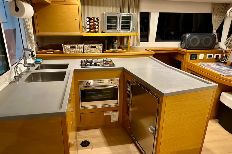Slide: The Image of Modern kitchen interior on a 2016 Lagoon 450 S yacht, featuring sleek countertops and appliances. - 77