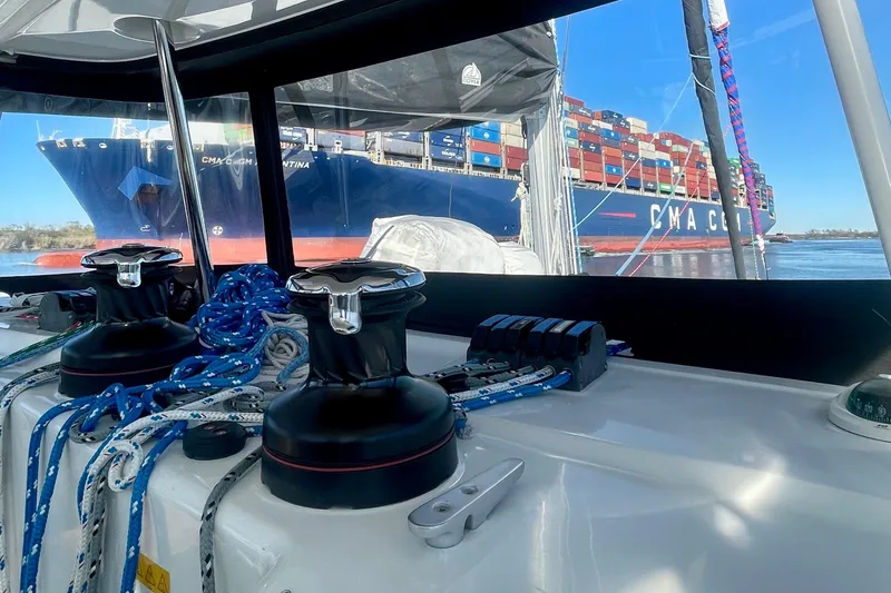 Slide: The Image of Lagoon 450 S catamaran interior with view of large cargo ship on the water. - 8