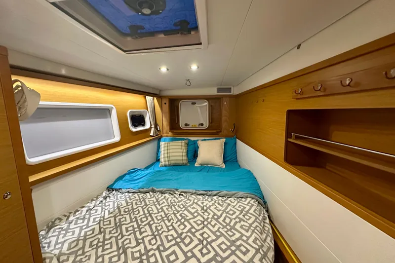 Slide: The Image of Cozy cabin interior of 2016 Lagoon 450 S catamaran with bed and wooden accents. - 86