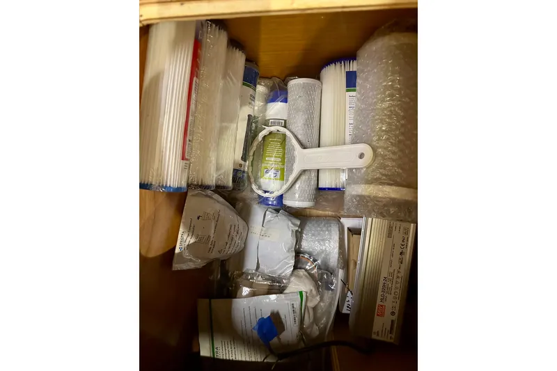 Slide: The Image of Storage compartment with various packaged items and tools on a 2016 Lagoon 450 S yacht. - 89
