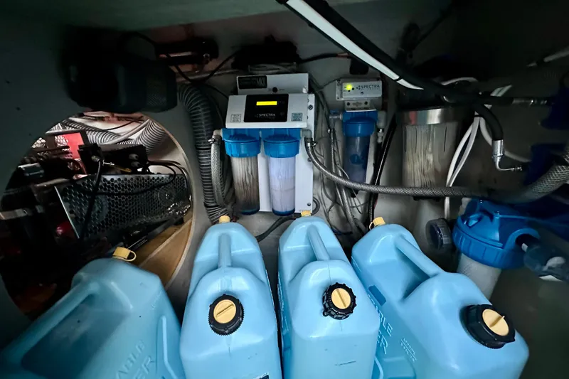 Slide: The Image of Engine room of 2016 Lagoon 450 S with water filtration system and blue containers. - 96