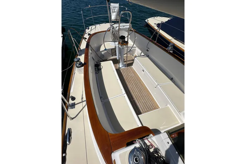 Slide: The Image of 2011 Alerion Sport 33 sailboat cockpit with wooden trim and seating, docked by the water. - 5