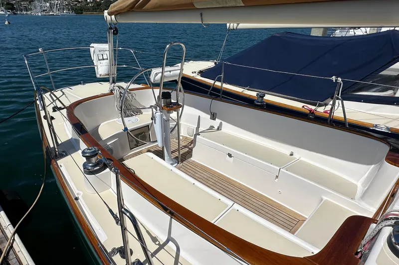Slide: The Image of 2011 Alerion Sport 33 sailboat cockpit with wooden trim, docked in a marina. - 7