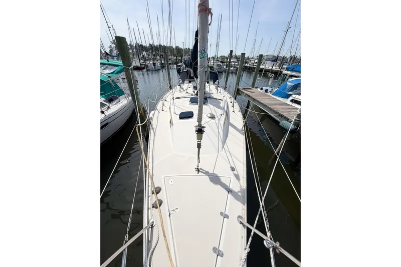 Slide: The Image of 2001 Caliber 40LRC sailboat docked in a marina, surrounded by other boats. - 13