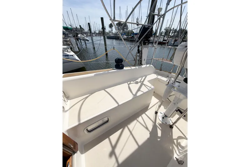 Slide: The Image of 2001 Caliber 40LRC sailboat cockpit with marina view, featuring clean deck and railing. - 18