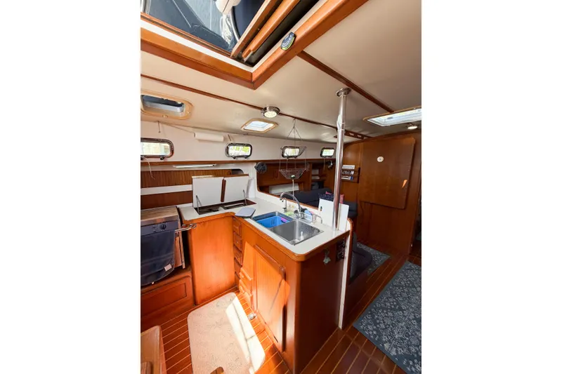 Slide: The Image of Interior of 2001 Caliber 40LRC sailboat with wooden cabinetry and compact kitchen area. - 33