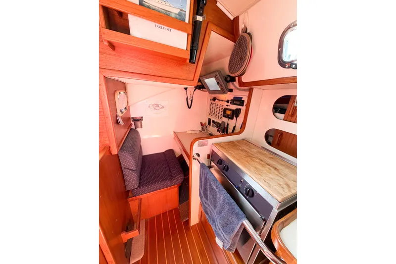 Slide: The Image of Cozy 2001 Caliber 40LRC yacht interior with seating and compact kitchen area. - 35