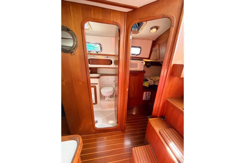 Slide: The Image of Interior of 2001 Caliber 40LRC yacht featuring wooden finishes and compact bathroom. - 42
