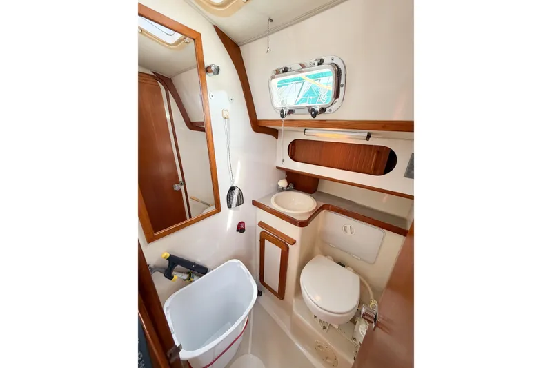 Slide: The Image of Bathroom interior of 2001 Caliber 40LRC yacht with wooden accents and porthole window. - 47