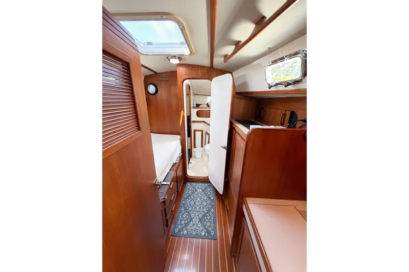 Slide: The Image of Interior of 2001 Caliber 40LRC sailboat with wooden cabinetry and cozy sleeping area. - 53
