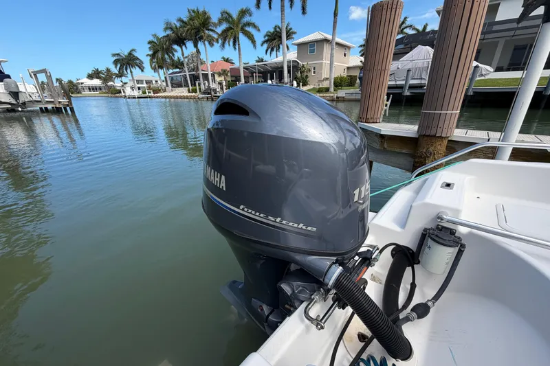 Slide: The Image of Boat with Yamaha 115 outboard motor docked in a scenic waterfront area. - 13