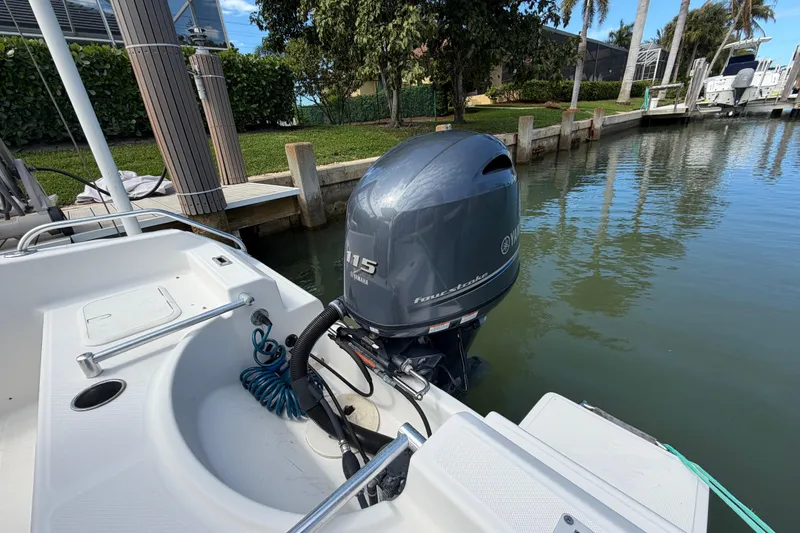 Slide: The Image of Boat with Yamaha 115 outboard motor docked in a serene marina setting. - 14