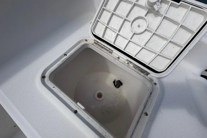 Slide: The Image of Open storage compartment on 2017 Release 196 RX boat, featuring a textured lid. - 17