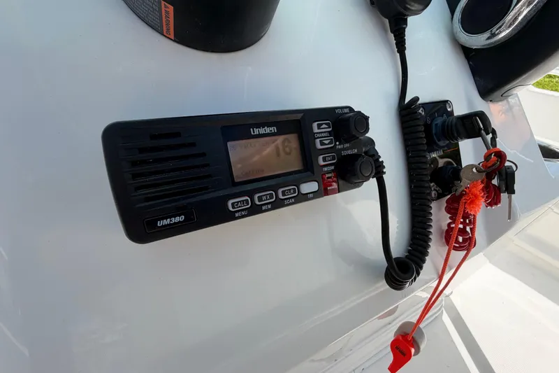 Slide: The Image of Marine radio and keys on a 2017 Release 196 RX boat dashboard. - 28