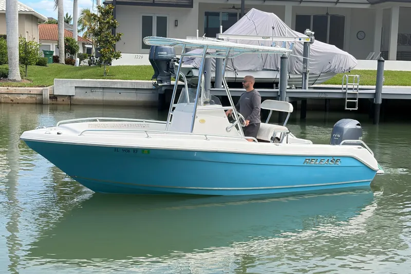 Slide: The Image of A 2017 Release 196 RX boat with a blue hull cruising on calm waters. - 3