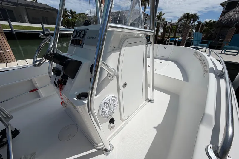 Slide: The Image of 2017 Release 196 RX boat interior with steering console and seating, docked near water. - 33