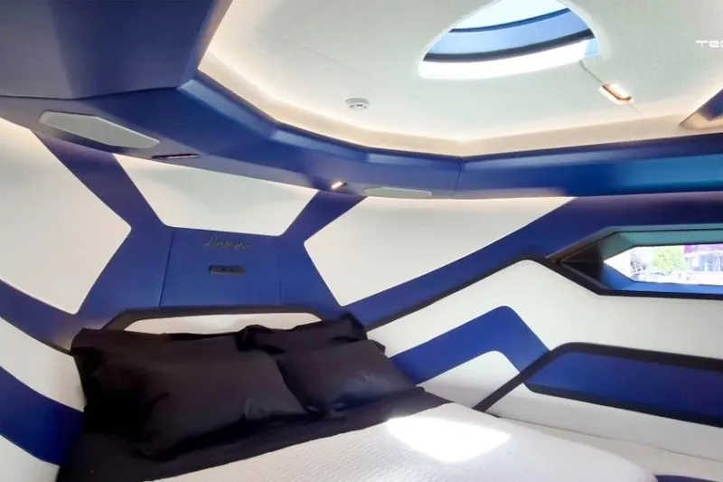 Slide: The Image of Luxurious Tecnomar LY63 2026 yacht interior with modern blue and white design, featuring a cozy bed. - 4