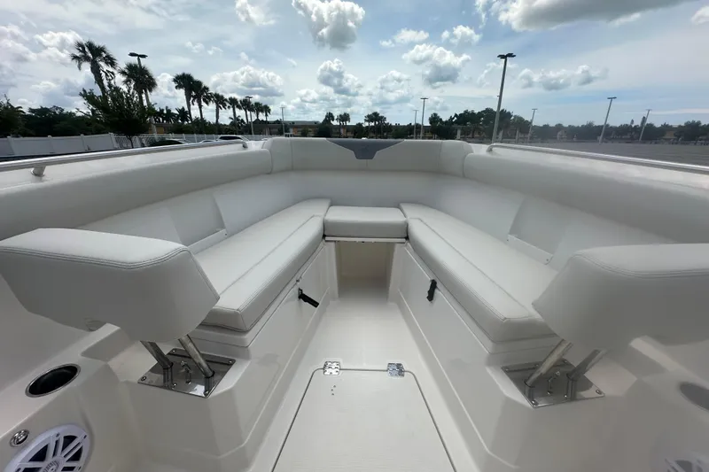 Slide: The Image of 2026 Sailfish 272 CC boat interior with white cushioned seating under cloudy sky. - 12