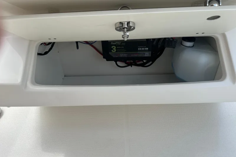 Slide: The Image of Storage compartment of 2026 Sailfish 272 CC boat, featuring battery and container. - 17
