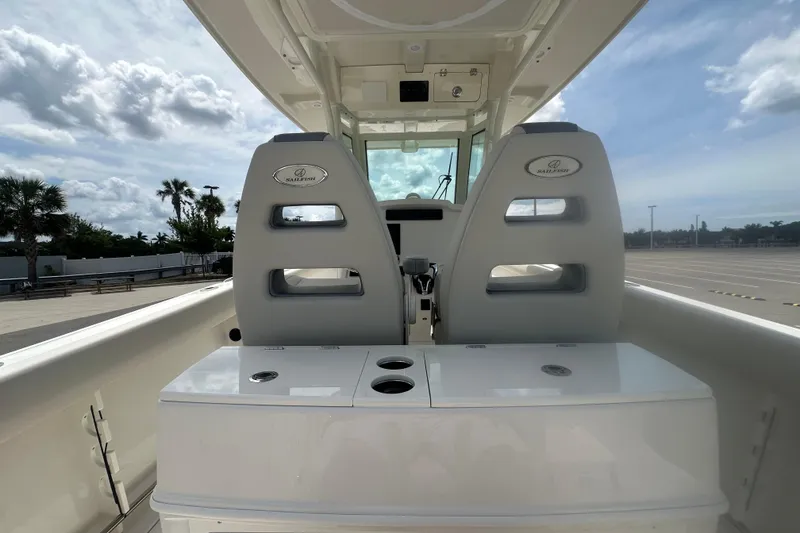 Slide: The Image of 2026 Sailfish 272 CC boat interior with dual seats and storage compartments under a cloudy sky. - 18