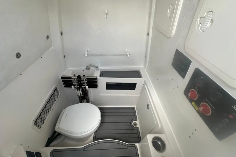 Slide: The Image of Interior of 2026 Sailfish 272 CC boat featuring a compact marine toilet and sink. - 22
