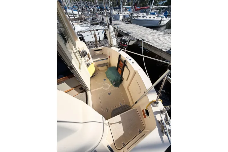 Slide: The Image of 2007 Island Packet SP Cruiser sailboat cockpit at marina, showcasing spacious deck and seating area. - 12