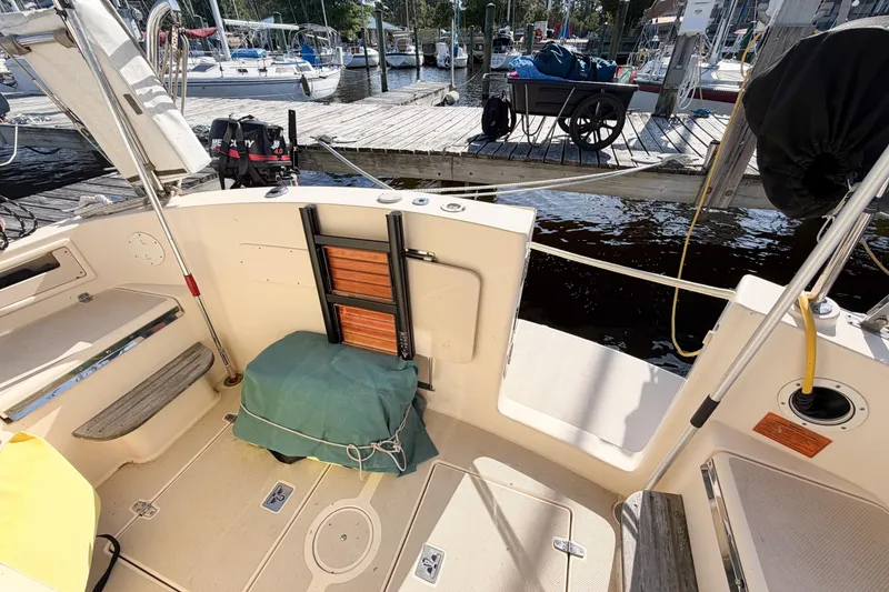 Slide: The Image of 2007 Island Packet SP Cruiser cockpit with dock view, featuring ladder and covered equipment. - 27